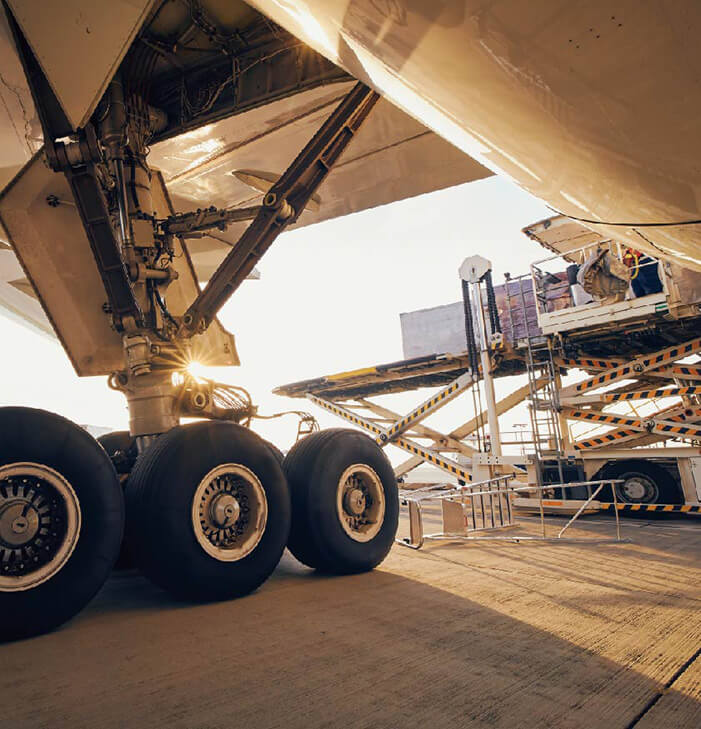航空機の主脚付近で貨物を積み下ろしする様子